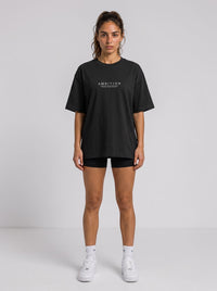 Ambition Limitless black organic cotton oversized t-shirt with drop shoulders and white chest logo on a model
