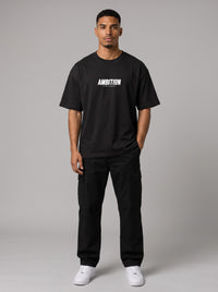 Ambition Limitless black organic cotton oversized t-shirt with drop shoulders and white chest logo on a male model