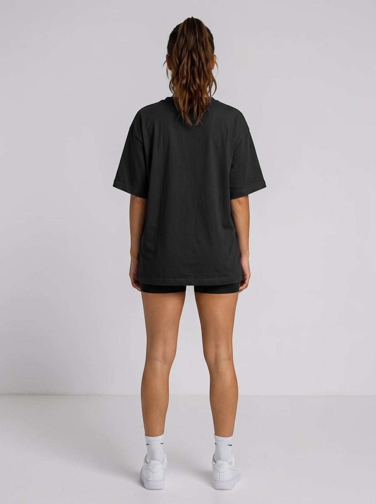 Ambition Limitless black organic cotton oversized t-shirt with drop shoulders, back view on a woman