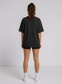 Ambition Limitless black organic cotton oversized t-shirt with drop shoulders, back view on a woman