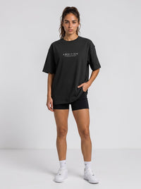 Ambition Limitless black organic cotton oversized t-shirt with dropped shoulders and white chest logo on a model
