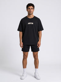 Ambition Limitless black organic cotton oversized t-shirt with drop shoulders and white chest logo on a male model