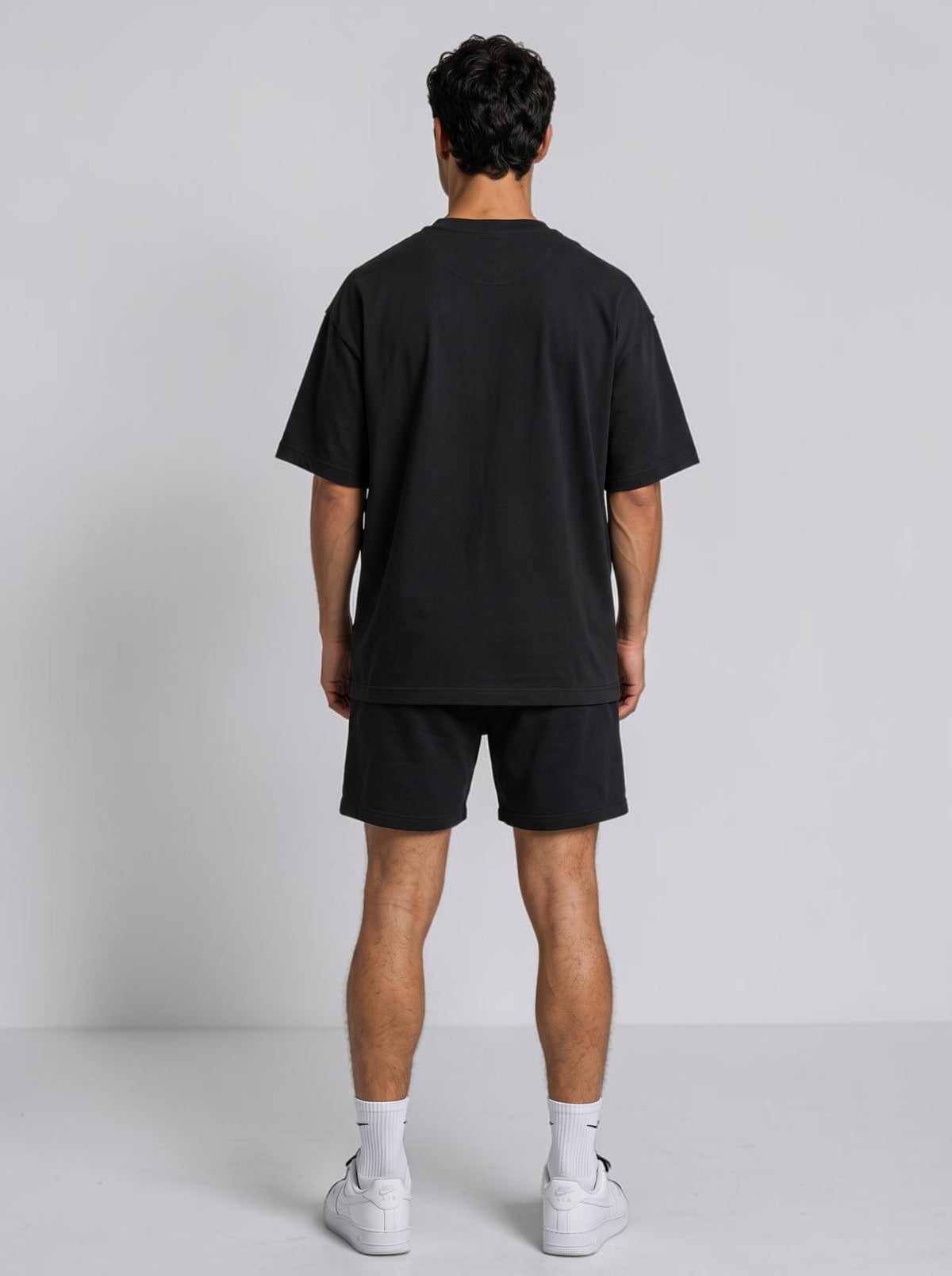 Back view of a man wearing an Ambition Limitless black oversized organic cotton t-shirt with dropped shoulders.