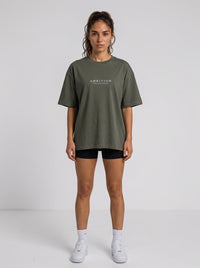 Woman wearing an Ambition Limitless olive green organic cotton oversized t-shirt with dropped shoulders