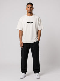 Ambition Limitless oversized off-white organic cotton t-shirt with black logo on chest worn by a male model
