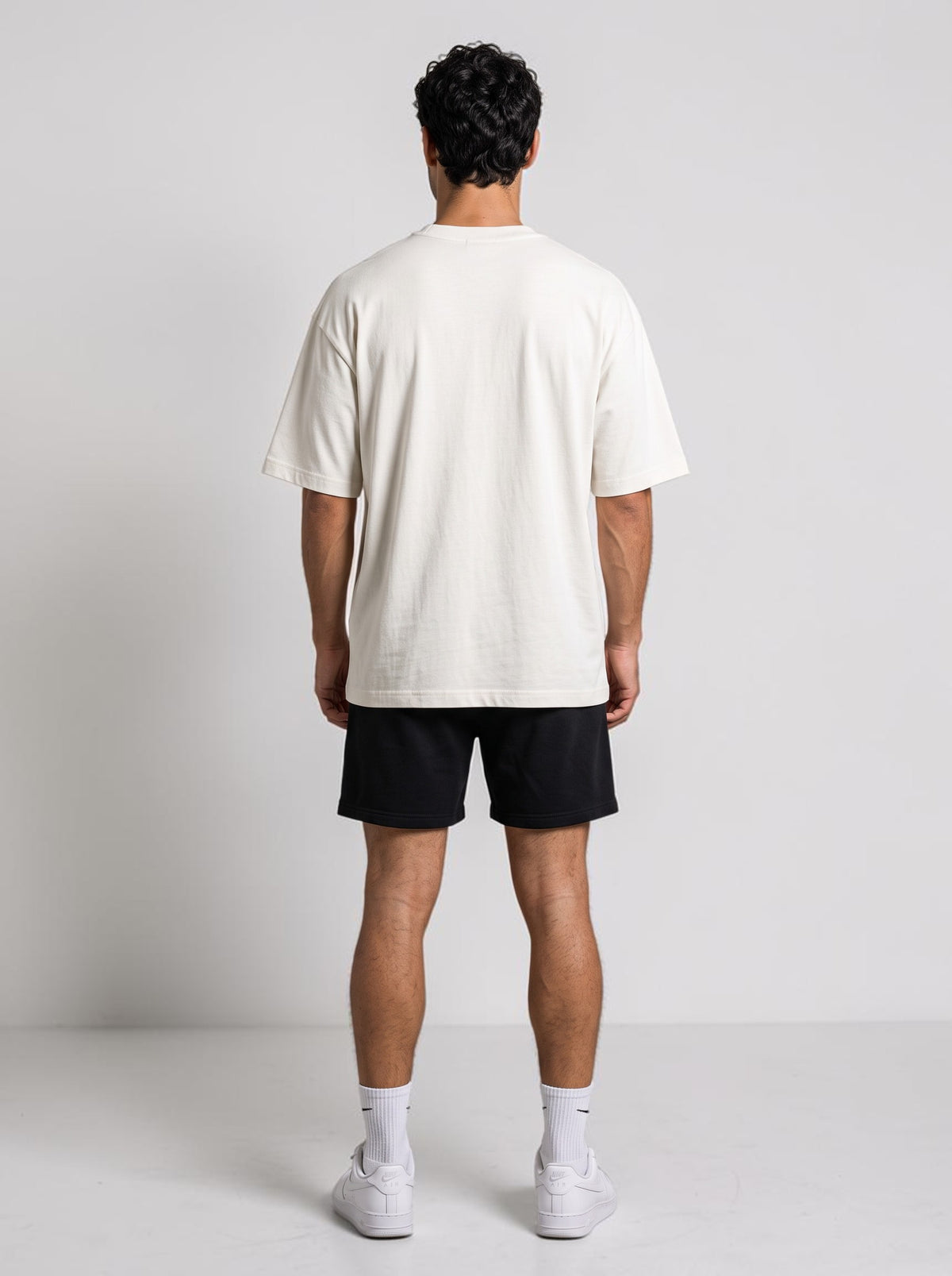 Back view of a man wearing an Ambition Limitless oversized off-white organic cotton t-shirt with dropped shoulders.