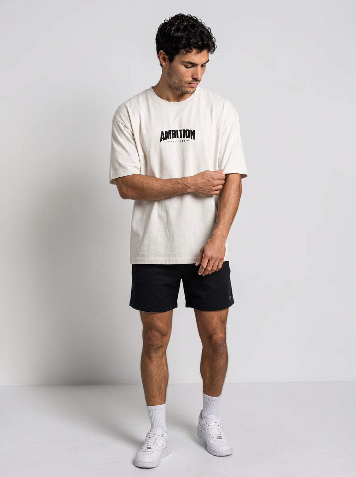 Ambition Limitless oversized off-white organic cotton t-shirt with black logo on chest worn by a male model
