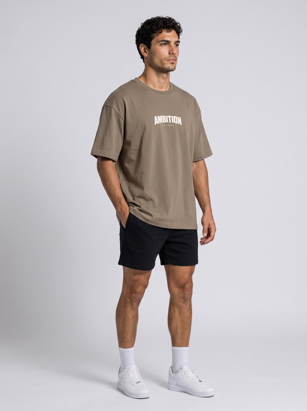 Ambition Limitless oversized taupe organic cotton t-shirt with drop shoulders and white chest logo on a male model.